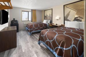a hotel room with two beds and a flat screen tv at Super 8 by Wyndham Mentor/Cleveland Area in Mentor