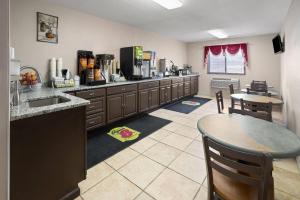 a kitchen with a sink and a counter with a table at Super 8 by Wyndham Mentor/Cleveland Area in Mentor