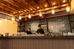 two men standing behind a bar in a restaurant at Eloína Hotel Boutique in Chiapa de Corzo
