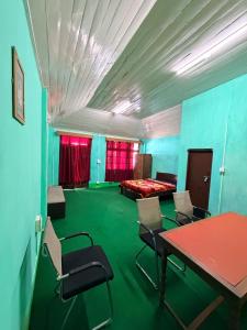 a room with a table and chairs and a bed at Kalimpong Heritage Homestay in Kalimpong