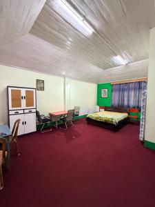 a room with a bed and a table and chairs at Kalimpong Heritage Homestay in Kalimpong