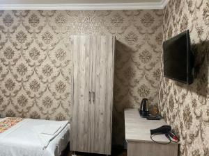 a bedroom with a bed and a tv on the wall at Guest House Silver in Samarkand