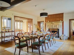 a dining room with a table and chairs and a fireplace at Great Bidlake Manor in Bridestowe