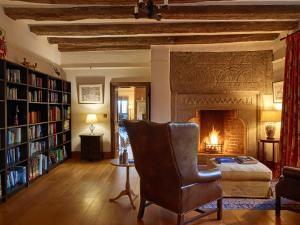 a living room with a chair and a fireplace at Great Bidlake Manor in Bridestowe