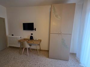 a room with a desk and a refrigerator and a table at Casa a Pennello Bed & Breakfast - Dove l'arte incontra l'ospitalità in San Benedetto del Tronto
