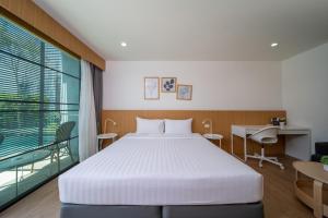 ein Schlafzimmer mit Bett, Schreibtisch und Fenster in der Unterkunft Xen Pool Access Phuket in Chalong  + 62 Fotos