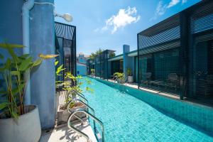 ein Schwimmbecken an der Seite eines Gebäudes in der Unterkunft Xen Pool Access Phuket in Chalong 