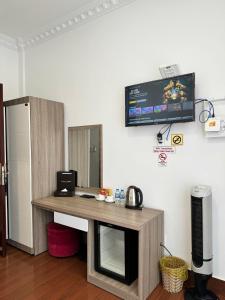 a room with a desk with a tv on the wall at Tommy hotel khe sanh dalat in Da Lat