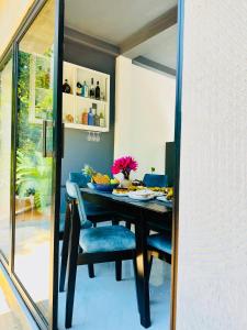 a dining room with a black table and blue chairs at Villa Cascade in Akuressa +20 photos