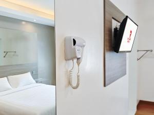 a hotel room with a phone and a bed at Red Planet Cebu in Cebu City +30 photos
