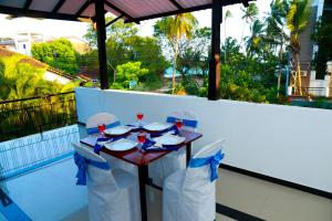a table with chairs and wine glasses on a balcony at Anila Beach Inn in Tangalle