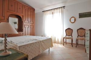 um quarto com uma cama, um espelho e uma janela em The Dream House in Sardinia em Bari Sardo