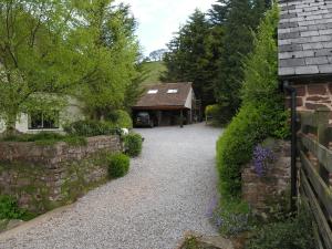 a driveway leading to a house with a stone wall at Bilbrook- Ukc4913 in Timberscombe