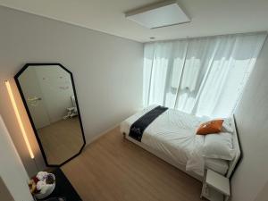 a bedroom with a mirror next to a bed at 해변1분 숙소 광안이즘, 1 min to beach Gwangan-ism in Kwangan-dong +28 photos