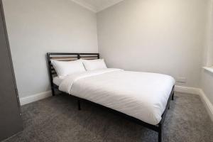 a bed with white sheets and pillows in a room at Stylish double room in Mansfield
