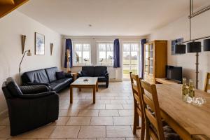 a living room with a couch and a table at Haus im Halligweg 20 in Nordstrand