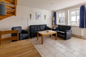a living room with two couches and a table at Haus im Halligweg 20 in Nordstrand