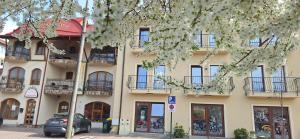 a building with cars parked in front of it at Pensiunea Normandia in Timişoara