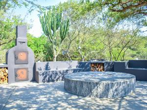 a patio with a firepit and a table with a fire hydrant at Syeta Bush Lodge - Sunset View in Nelspruit +11 photos