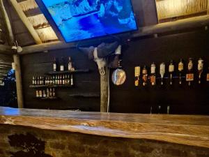 a bar with a wooden counter and a tv on the wall at Syeta Bush Lodge - Sunset View in Nelspruit