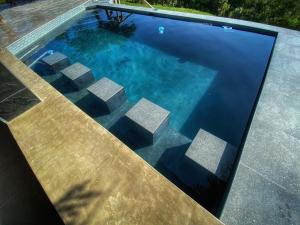 an overhead view of a swimming pool with blue water at Syeta Bush Lodge - Sunset View in Nelspruit