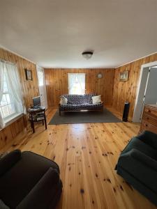 a bedroom with a bed and a wooden floor at THE SHOPPE LIMIT 3 cabin in North Sebago