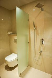 a bathroom with a toilet and a glass shower stall at DHANUSH STAYS - A Boutique Accommodation in Varanasi