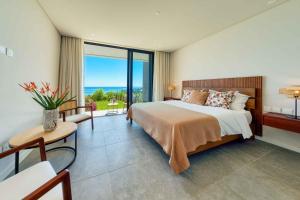 a bedroom with a large bed and a large window at Domaine d'Anbalaba in Ruisseau Créole