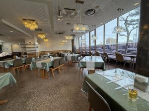 a restaurant with green tables and chairs and windows at APA Hotel Okhotsk Kitami in Kitami