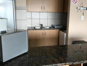 a kitchen with a sink and a refrigerator at Lescalier 513 Luxury sea facing unit in Amanzimtoti