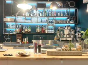 a kitchen with a counter with a lot of bottles at Hotel Nizza Creative Hotel in Rimini