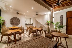 a restaurant with tables and chairs in a room at The Balangan Hotel Uluwatu - 2min to Beach & 5min to Bali's Best Golf in Uluwatu
