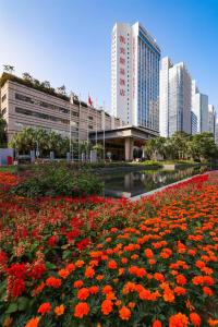 a field of red flowers in front of a building at Kempinski Hotel Shenzhen in Shenzhen