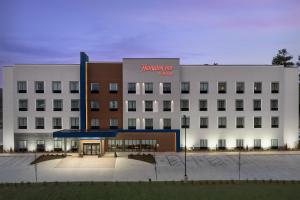 a large white building with a sign on it at Hampton Inn By Hilton Clanton in Clanton