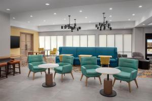 a lobby with a blue couch and chairs and tables at Hampton Inn By Hilton Clanton in Clanton
