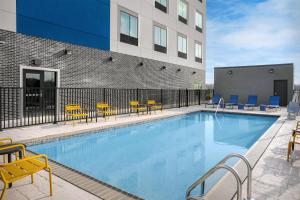 a swimming pool with chairs and a building at Hampton Inn By Hilton Clanton in Clanton