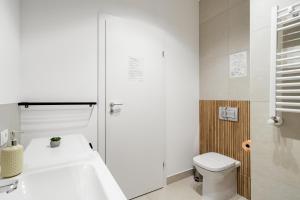 a bathroom with a white tub and a toilet at Sika Platinum Apartment - cazare premium Arad - self check-in in Arad +30 photos