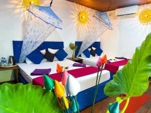 a bedroom with a bed with colorful pillows and plants at Nature Rest Ashored in Sigiriya +99 photos