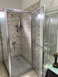 a shower with a glass door in a bathroom at Beverley Manor DIAMOND VALE' 2 Bedroom 1 Bath Apartment in Diego Martin +53 photos