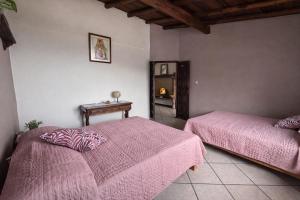 a bedroom with two beds and a table and a mirror at Entre el sol y la luna in Taxco de Alarcón