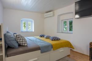 a bedroom with a bed with pillows on it at Veli Lošinj Old Town Apartments in Veli Lošinj