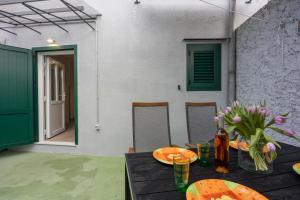 a table with a vase of flowers on it at Veli Lošinj Old Town Apartments in Veli Lošinj