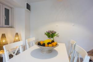 a white table with a bowl of fruit on it at Veli Lošinj Old Town Apartments in Veli Lošinj