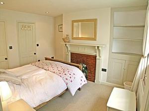 a bedroom with a bed and a fireplace at Kingsley Cottage in Instow