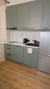 a kitchen with white cabinets and a white refrigerator at Peetri Plats Border Apartmens in Narva