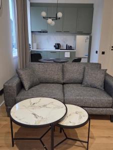 a living room with a couch and two tables at Peetri Plats Border Apartmens in Narva