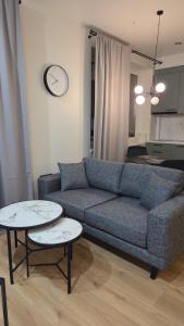 a living room with a couch and two tables at Peetri Plats Border Apartmens in Narva
