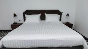 a bedroom with a large white bed with two lamps at Le Noci Room 2203 in Ao Nang Beach