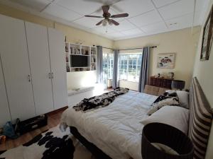 a bedroom with a large bed and a ceiling fan at Country Barns Guest house in Wakkerstroom +10 photos