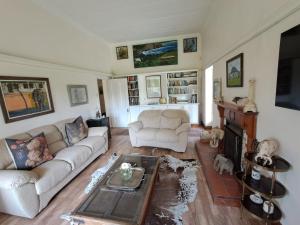 a living room with a couch and a table at Country Barns Guest house in Wakkerstroom